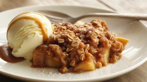 Gooey Apple Crisp on a plate with vanilla ice cream