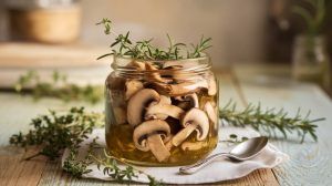 Mushroom Conserva in a mason jar on a plate garnished with fresh herbs
