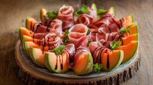 Prosciutto-Wrapped Melon slices on a wood platter