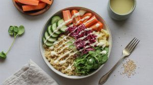 bowl of quinoa and veggies drizzled with dressing