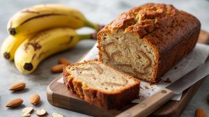 almond flour banana bread on a wood cutting board with bananas in the background
